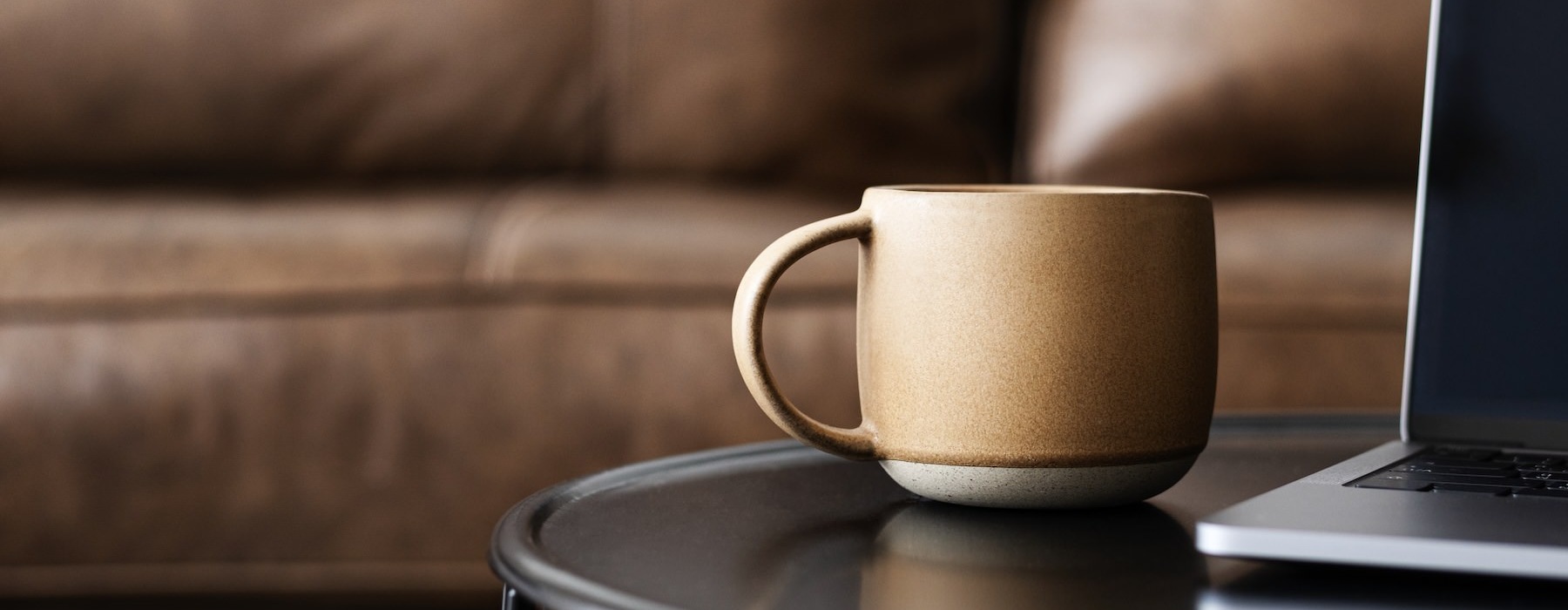 a table with a cup of coffee and a computer